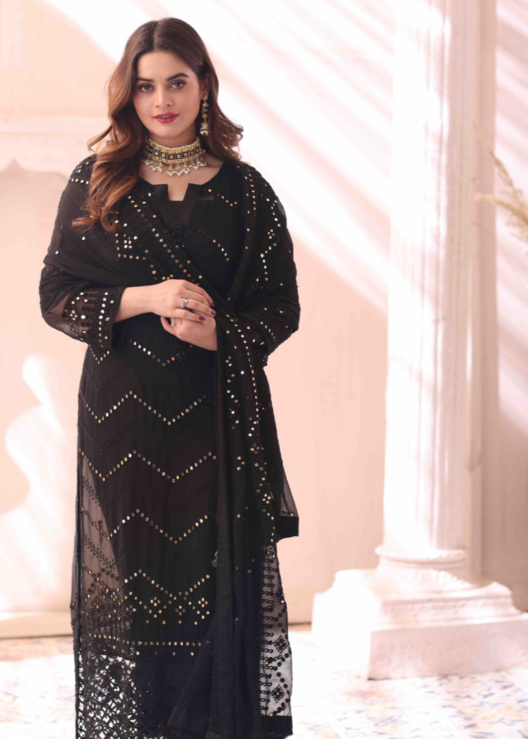 A female model standing in the well lighted space wearing black Embroidered Chiffon Suit with dupatta.