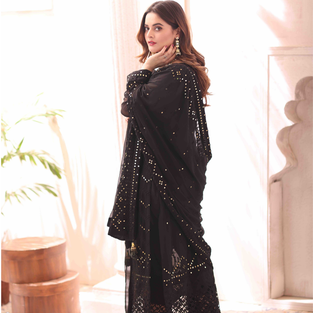A girl standing sidewise looking to her left in Embroidered Chiffon Suit.