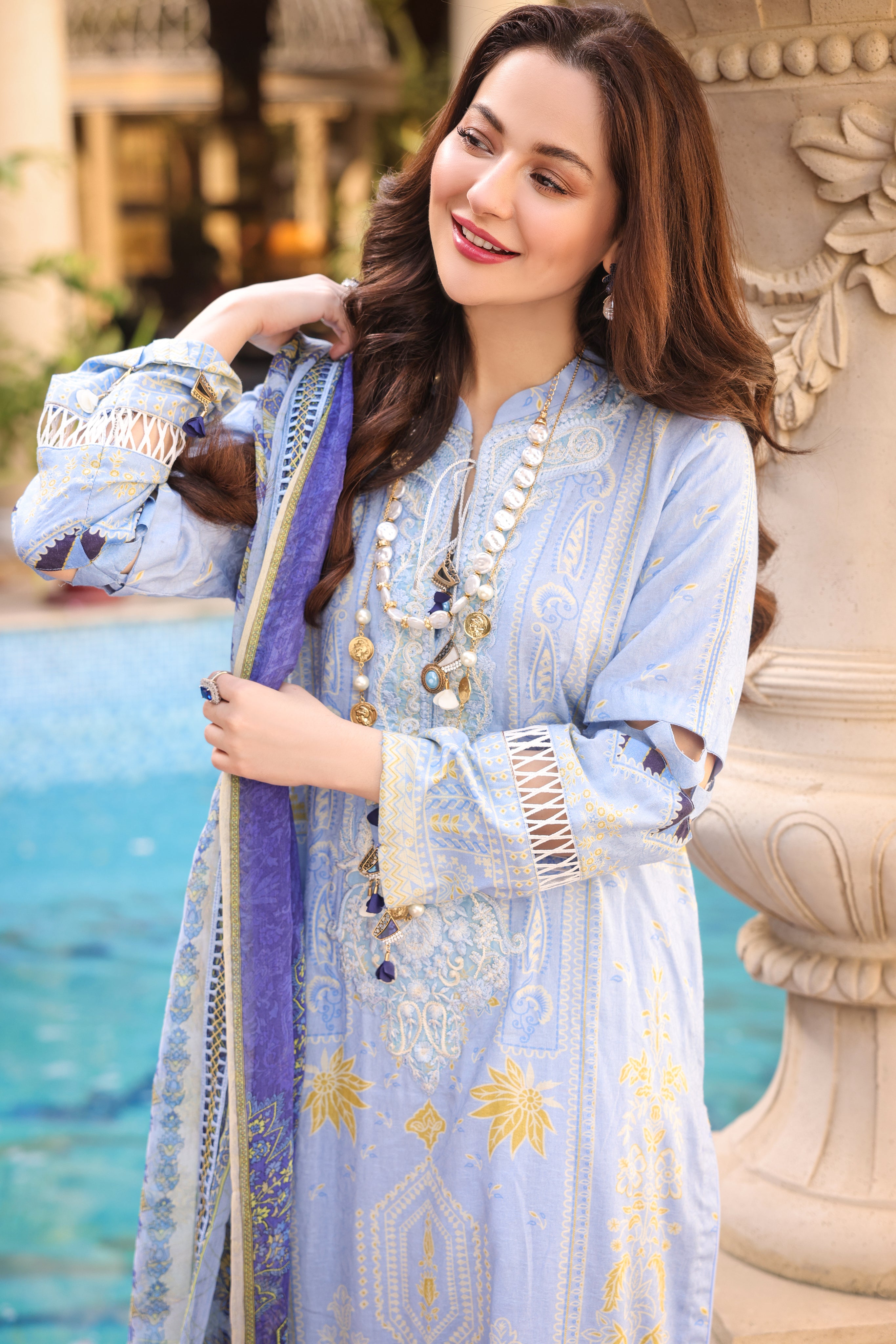 A girl setting her dupatta on shoulders while wearing a 3 Piece Embroidered Organza Suit.