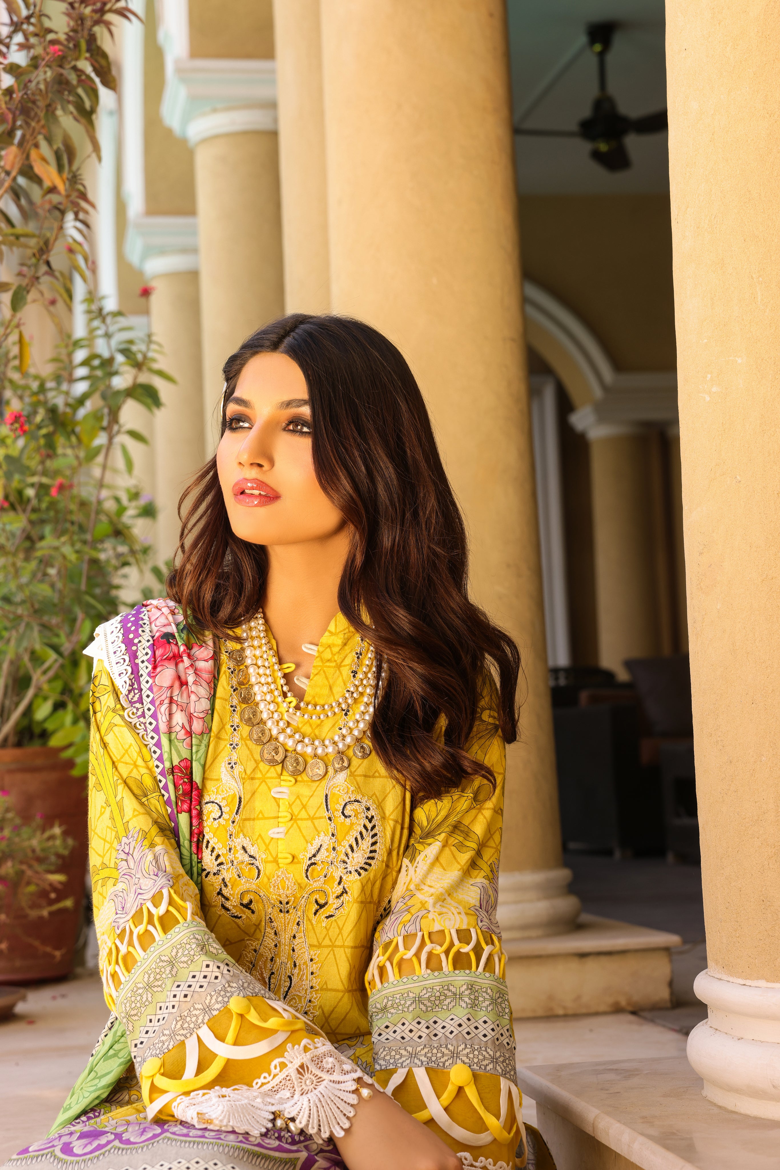 A girl is sitting wearing a 3 Piece Embroidered Organza Suit.