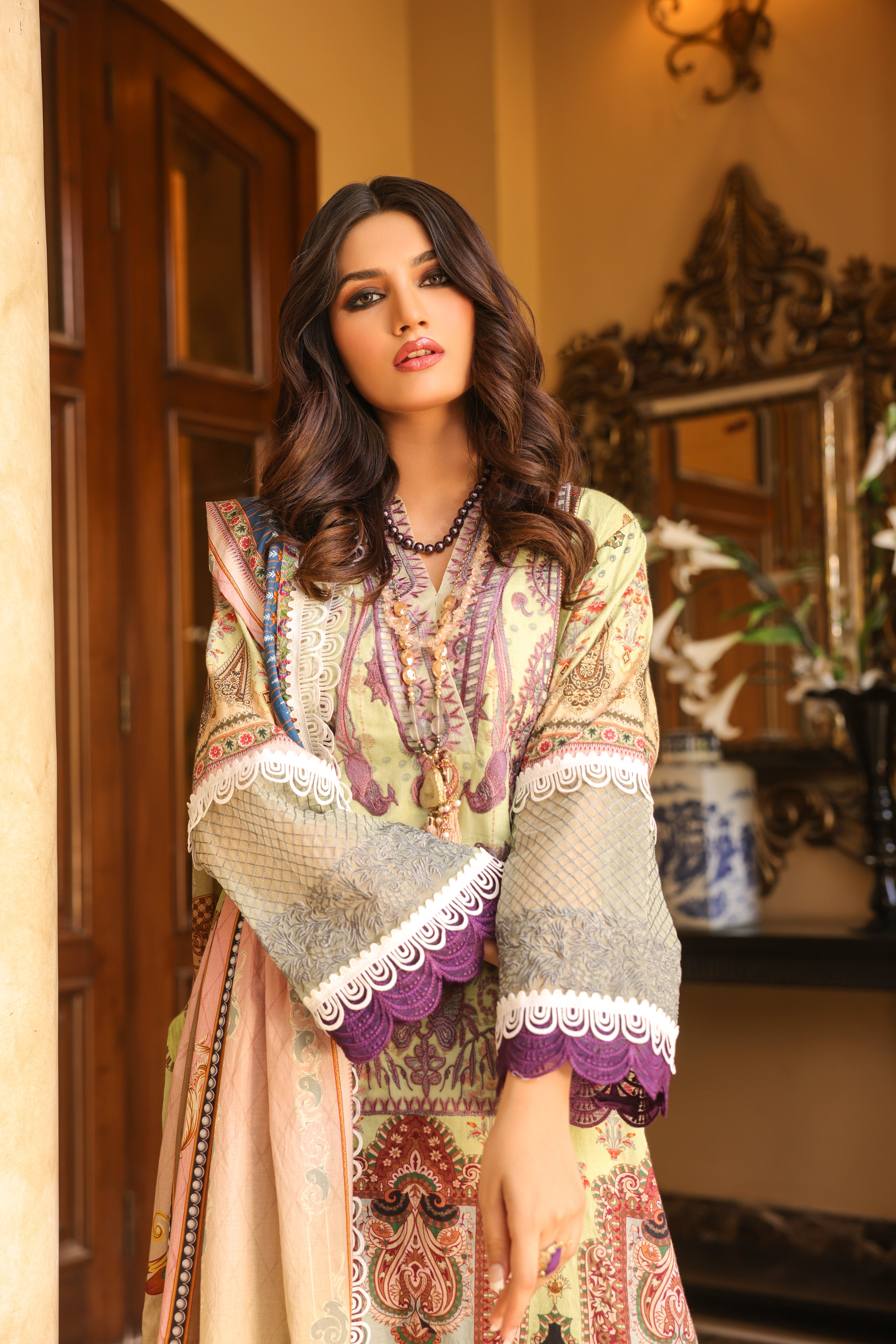 A girl is standing showing her dress Digital Lawn Suit with Embroidered Selves.