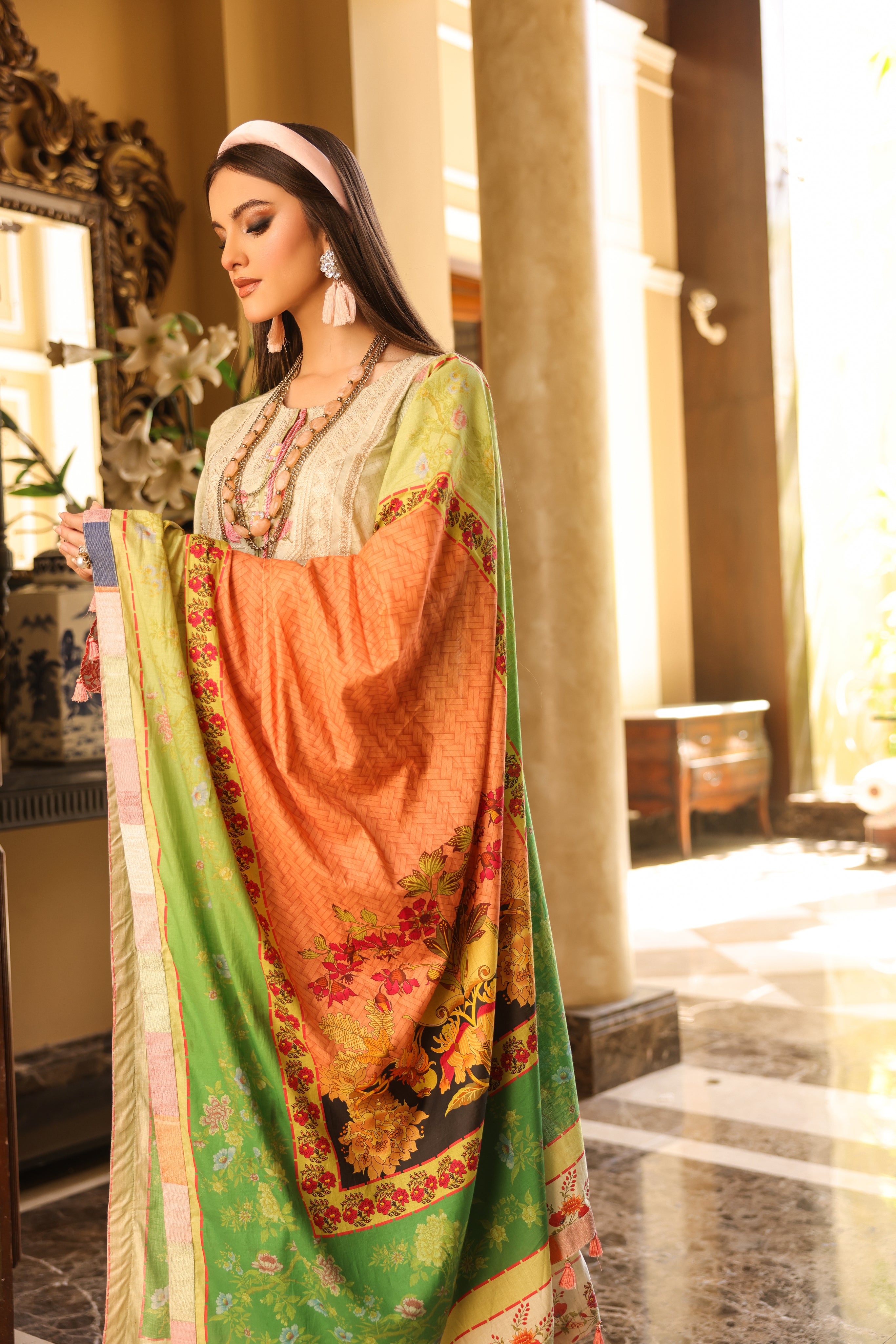 A female model holding a branch of plant in hand whie wearing an Embroidered Organza Suit